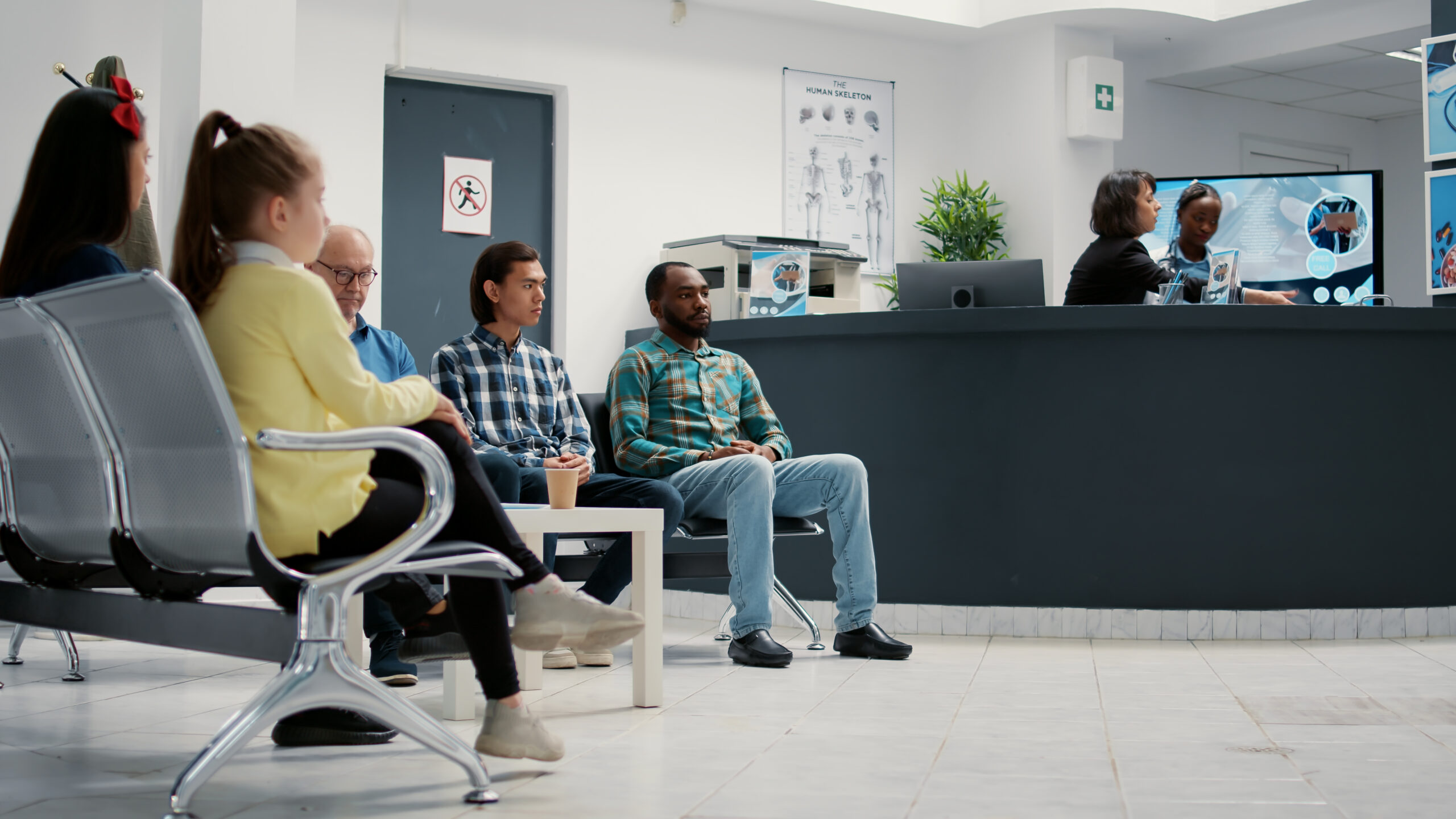 Patient sitting in a waiting room at a primary care clinic in Indianapolis, Indiana, deciding between urgent care and a scheduled provider visit.